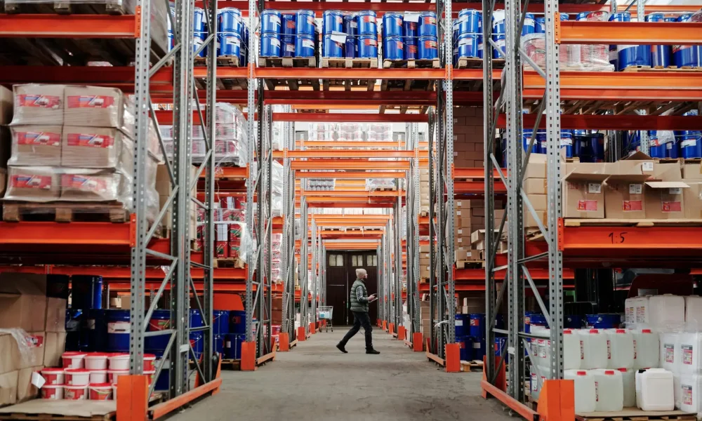 Stock photo of a foreman walking through a warehouse and reviewing the stock